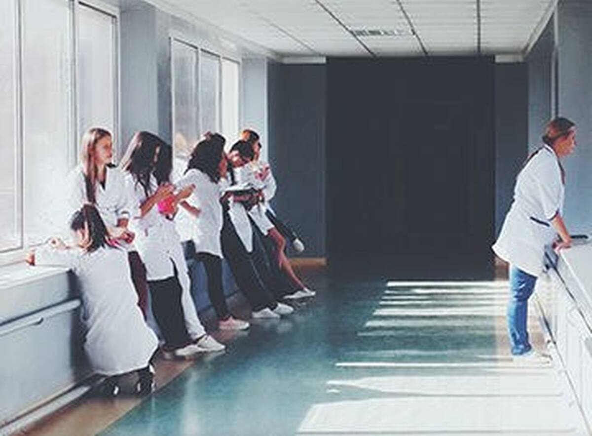 Healthcare workers meet in a hospital corridor.