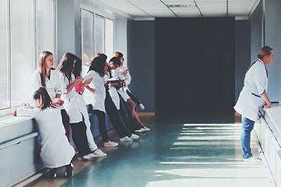 Healthcare workers meet in a hospital corridor.