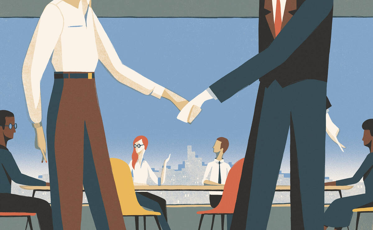A woman shakes a man's hand.