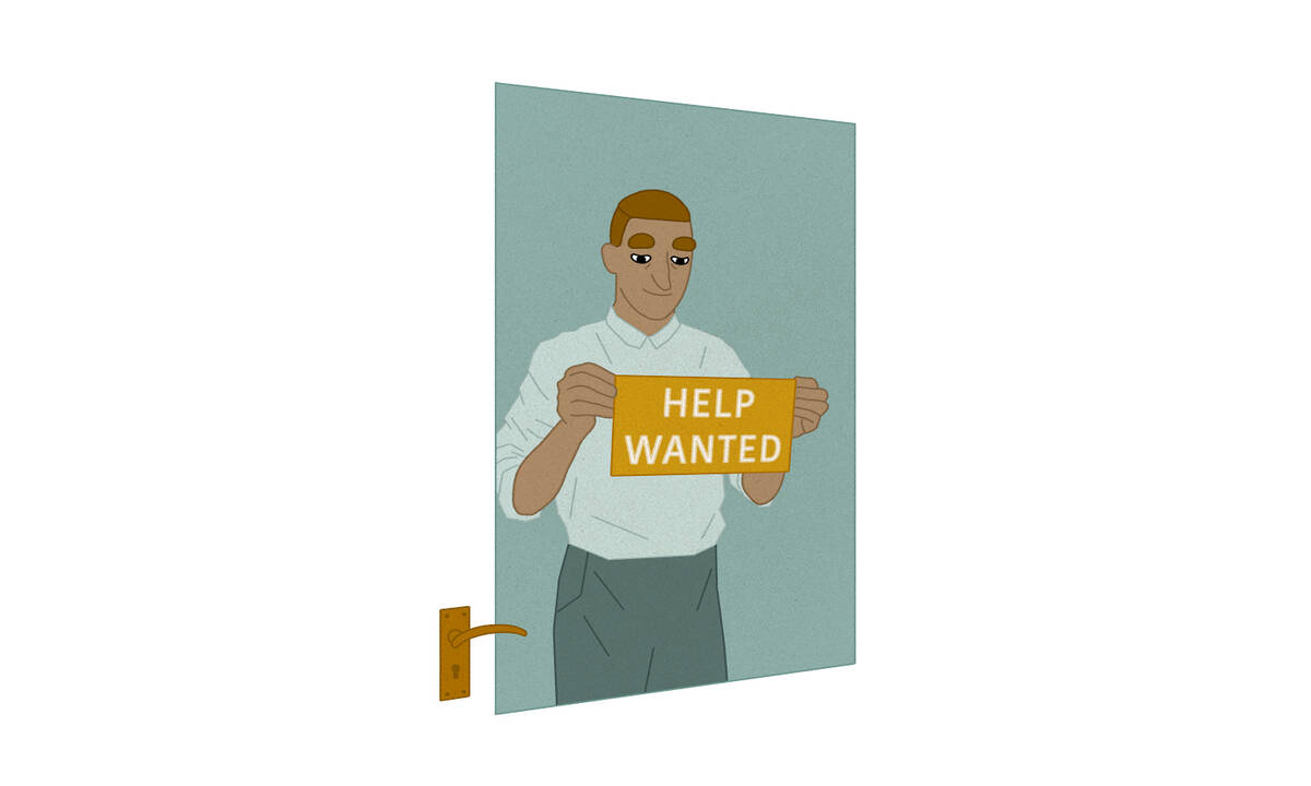 Man hanging "Help Wanted" sign in shop door