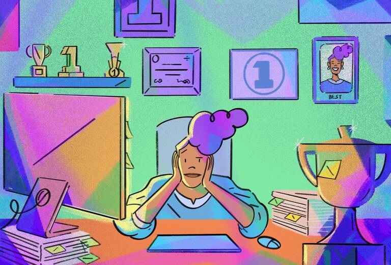 person sitting at desk with trophies around her