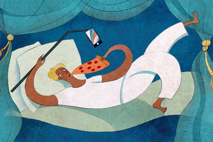 person in bed taking a selfie while eating pizza