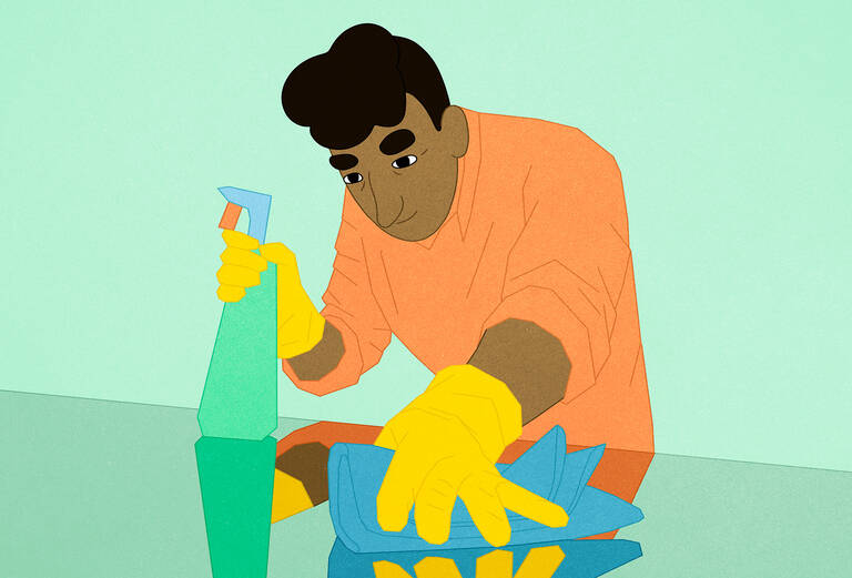 man washing surface clean with green product.